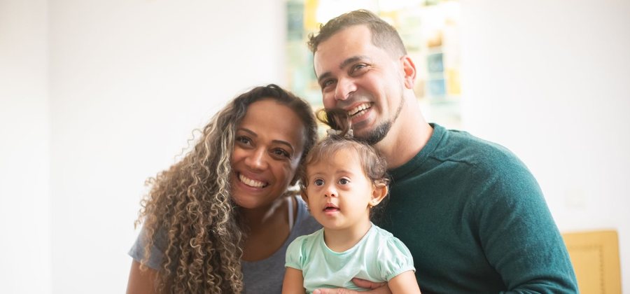Parents holding their young child at home — family protection cover